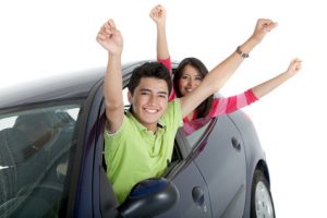 Happy couple coming out of the windows of a car - isolated over a white background
